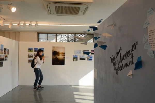 한 학생이 '흰, 천, 바람' 전시회에서 작품들을 구경하고 있는 모습