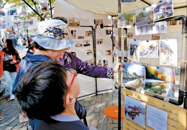지난달 19일, 주민들이 정릉2동 교통광장에서 열린 '2019 정릉버들잎축제'에서 사진전시를 바라보고 있다.