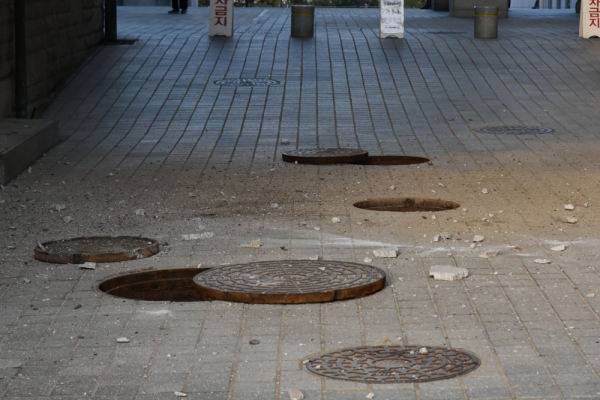 경영대에서 폭발한 맨홀 뚜껑 옆에 파편들이 흩어져 있다