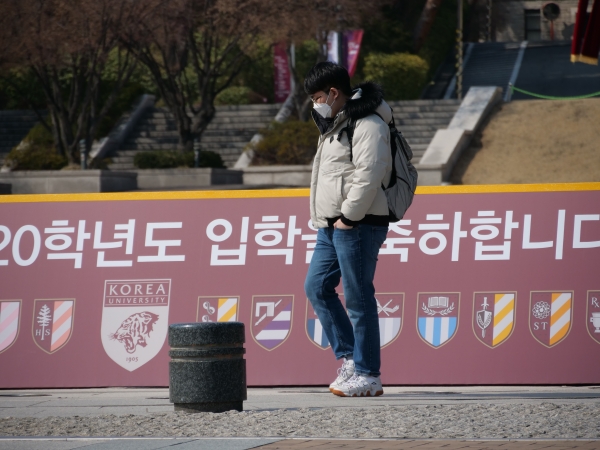 허탈한 입학 | 2일, 마스크 쓴 학생이 중앙광장에 설치된 입학 환영 포토월 앞을 지나가고 있다.