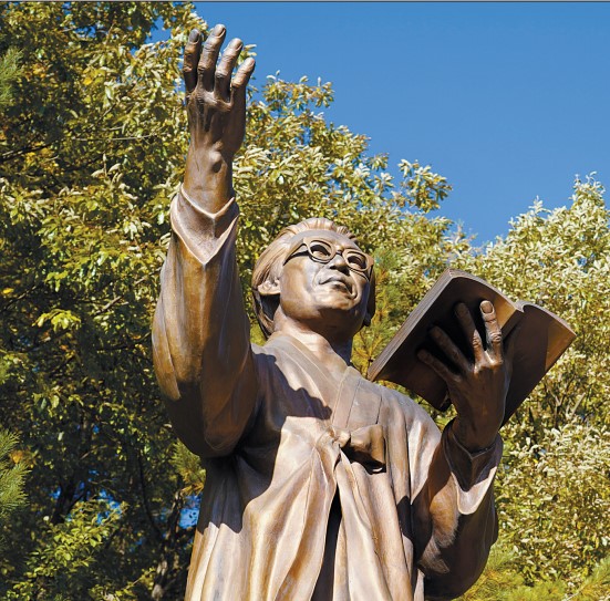 조지훈의 동상이 왼손엔 책을 쥐고 오른손은 높이 든 채 마을을 내려다보고 있다.