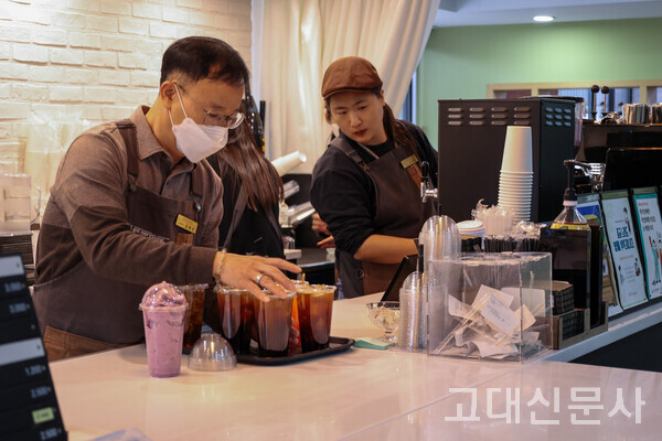 매니저 김태선(왼쪽) 씨와 조아라(오른쪽) 씨가 커피를 담고 있다.