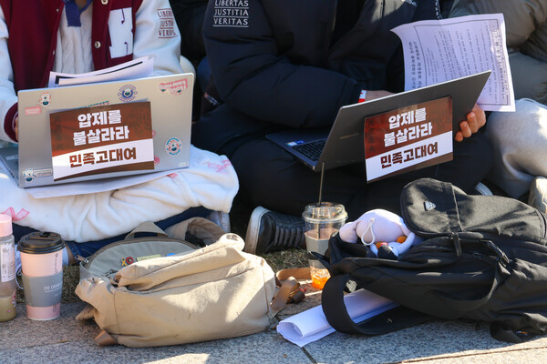 지난해 12월 6일,  학생들이 중앙광장에 앉아 학생총회 정족수가 차기를 기다리며 과제를 하고 있다.