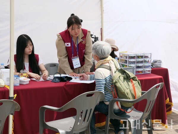 지난달 24일 서울캠 중앙광장에서 한 지역 주민이 진료를 위해 기록지를 작성하고 있다.