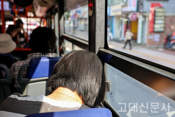 장거리를 이동하는 학생이 창문에 기대 잠을 청하는 모습.