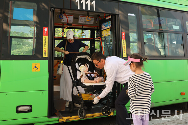 두 아이와 함께 저상버스에 탑승한 민예린(여·41) 씨가 운전기사의 도움을 받아 유아차를 내리고 있다.
