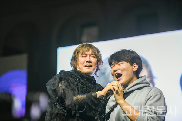 지난 22일 고려대 서울캠퍼스 민주광장 무대에서 가수 김장훈이 학생과 함께 노래하고 있다.