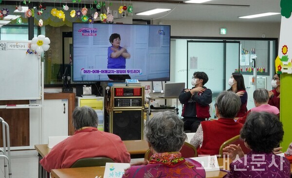 단원의 시범에 맞춰 건강박수 체조를 하고 있는 어르신들.