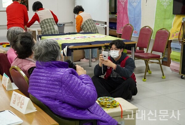 조승현(글비대 글로벌경영23) 씨가 사진기로 어르신의 모습을 담고 있다.