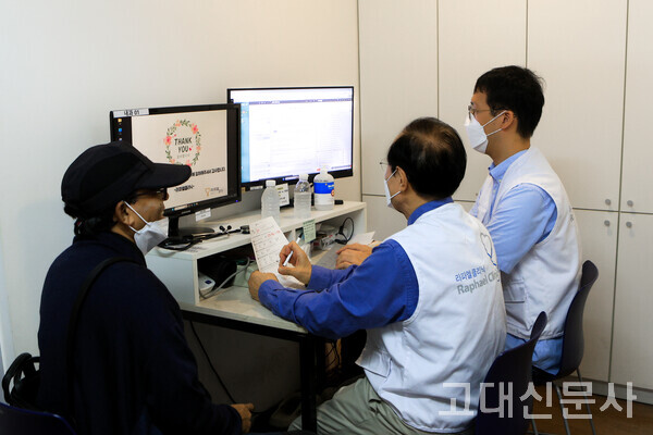 김동윤 씨가 김창덕(의과대 의학과) 명예교수와 함께 외국인 노동자를 진료하고 있다.