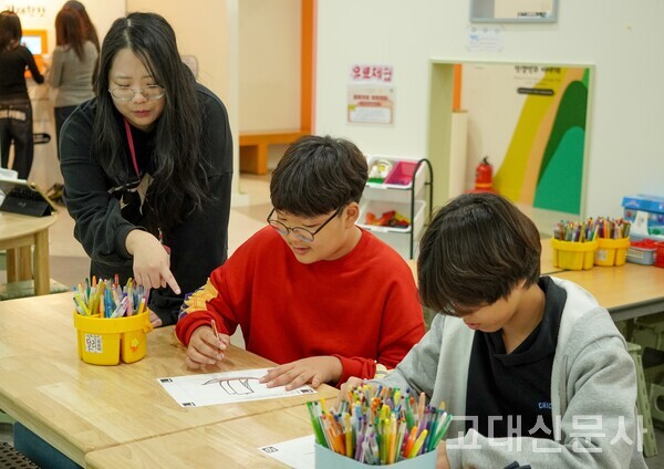 이유진 씨가 아이들에게 색칠하는 방법을 설명하고 있다.