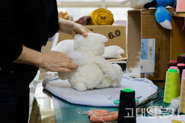솜이 빠진 인형에 새 솜이 채워지고 있다.