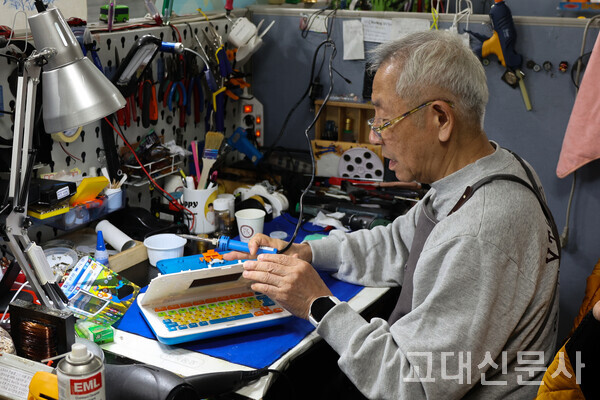 김성진 씨가 노트북 장난감의 회로기판을 수리하고 있다.