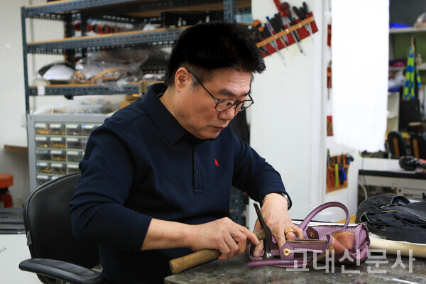 박영열 명품수선사가 가방의 가죽을 두들겨 밀착시키고 있다.