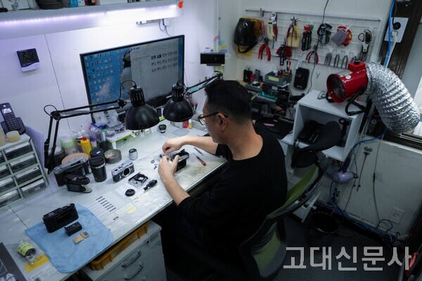 김진철 실장이 오래된 필름 카메라를 수리하고 있다.