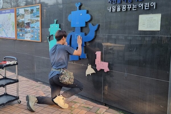 박현우 씨가 간판을 시공하고 있다.